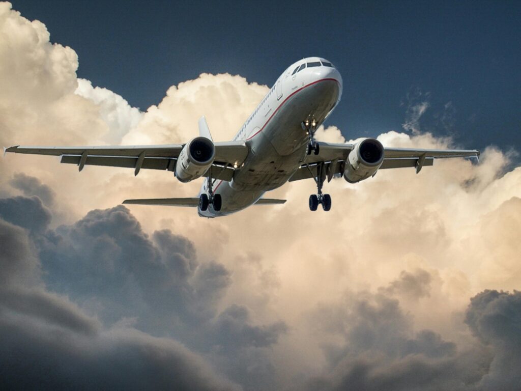 A commercial airplane flying through dramatic clouds, showcasing aviation in action.